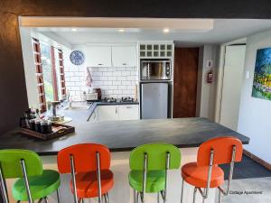 a kitchen with green and orange chairs in it at Stay at Seodin in Wilderness