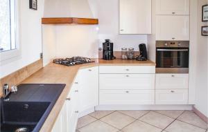 a kitchen with white cabinets and a black sink at Nice Home In Caunes Minervois With Wifi in Caunes-Minervois