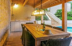 a dining room with a wooden table with wine glasses at Nice Home In Caunes Minervois With Wifi in Caunes-Minervois +10 photos