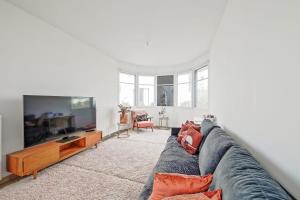 a living room with a couch and a tv at Villa Riviera Near Disneyland Paris in Chessy