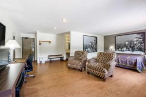 a hotel room with a bed and two chairs at Super 8 by Wyndham Zanesville in Zanesville