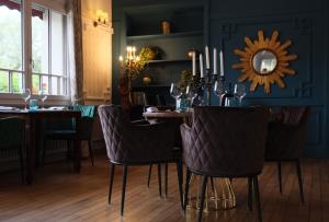 uma sala de jantar com uma mesa com cadeiras e um espelho em LOGIS HOTEL BELLEVUE RESTAURANT LA POMME d'OR em Coucy-le-Château-Auffrique