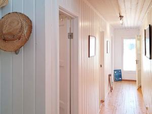 a hallway with a straw hat on the wall at Holiday home Søndeled in Søndeled