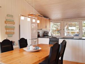 a kitchen and dining room with a wooden table and chairs at Holiday home Søndeled in Søndeled