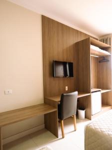 Habitación de hotel con cama y TV en la pared en Hotel Alji Salto, en Salto
