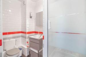 La salle de bains blanche est pourvue de toilettes et d'un lavabo. dans l'établissement Studio Centre belle vue mer, à Dinard