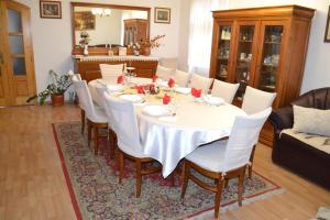 une salle à manger avec une table et des chaises blanches dans l'établissement Enikő Vendégház, à Cernatu de Sus