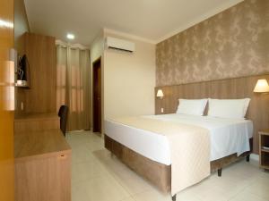 a bedroom with a large white bed in a room at Hotel Alji Salto in Salto