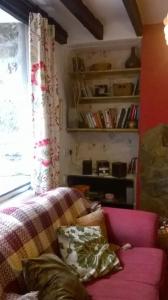 a living room with a pink couch and a window at Cosy cottage with mountain views in Blaenau-Ffestiniog