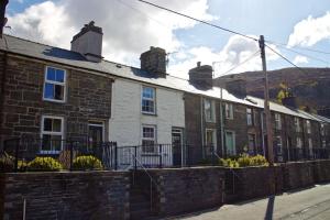 a row of brick houses on the side of a street at Cosy cottage with mountain views in Blaenau-Ffestiniog