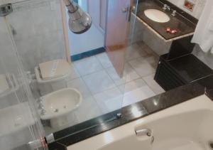 a bathroom with a shower and a toilet and a sink at Tower Icaraí Hotel in Niterói