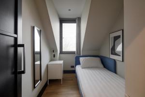 een kleine slaapkamer met een bed en een raam bij Broomhill Loft in Aberdeen