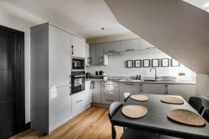 een keuken met witte kasten en een tafel en stoelen bij Broomhill Loft in Aberdeen