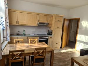 eine Küche mit einem Holztisch und einem Esszimmer in der Unterkunft Seevilla Wietjes Whg 2 in Baltrum