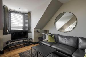 salon z czarną skórzaną kanapą i lustrem w obiekcie Broomhill Loft w Aberdeen