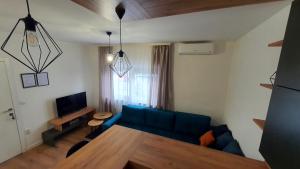 ein Wohnzimmer mit einem blauen Sofa und einem Tisch in der Unterkunft Apartman Campari in Banja Luka