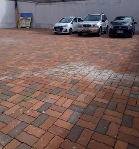 two cars parked in a brick parking lot at HOTEL DEL RIVER MONUMENTO in Sangolquí