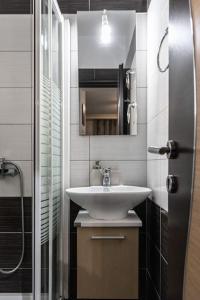 a bathroom with a sink and a shower at ΧΛΙΔΑΤΟ-ΟΝΕΙΡΕΜΕΝΟ-ΜΟΝΤΕΡΝο ΔΙΑΜΕΡΙΣΜΑ!!! in Larisa