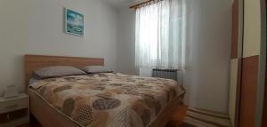 a bedroom with a large bed with a window at Apartments Dida moj in Šmrika