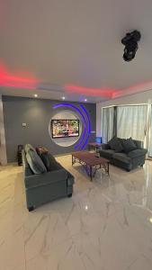 ein Wohnzimmer mit 2 Sofas und einem TV in der Unterkunft فيلا بلوبيتش بمسبح خاص وشاطى رملي in Durrat Al-Arus