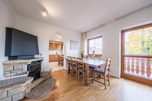 ein Wohnzimmer mit einem Kamin, einem Tisch und Stühlen in der Unterkunft Holiday Home Smržovka in Smržovka