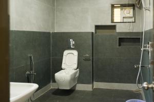 a bathroom with a white toilet and a sink at Hotel Voila Atnest Suites Kokapet, Business Hotel in Hyderabad