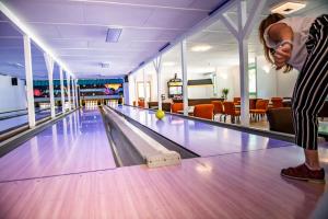 a man standing in a bowling alley with a ball at Termál Kemping Apartmanok és Bungalók in Harkány