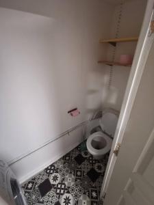 a bathroom with a toilet with a black and white tile floor at Le loft jeanne in Orléans
