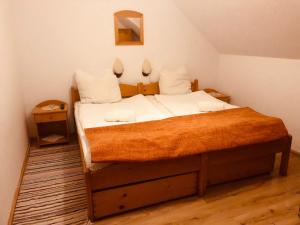 a bedroom with a bed with white sheets and a mirror at Enikő Vendégház in Cernatu de Sus