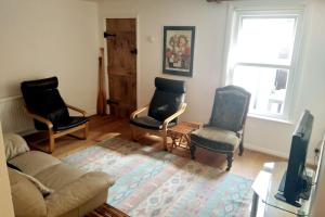 a living room with three chairs and a couch at Welcoming cottage in Chichester near City Centre in Chichester