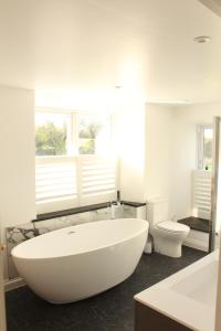 a bathroom with a large white tub and a toilet at Cippinstone in Newport Pembrokeshire +26 photos
