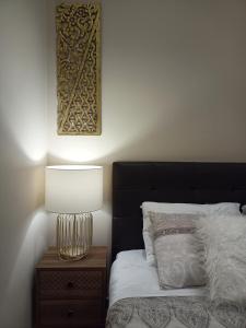 a bed with a black headboard and a lamp on a table at Nikola's & Joanna's apartments in Argostoli