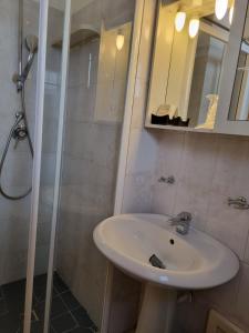 W łazience znajduje się umywalka i prysznic. w obiekcie Hotel Plammas w mieście Santa Maria Navarrese