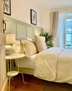 a bedroom with a bed and a table and a window at Blas at Fronlas Café - The heart of Newport in Newport Pembrokeshire