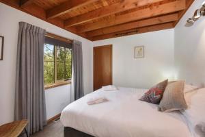 a bedroom with a large bed and a window at The Lodge Blackheath in Blackheath