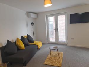 a living room with a couch and a tv at Superb modern flat in Northampton, parking &EV in Northampton