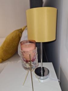 a lamp on a table with a candle in a vase at Superb modern flat in Northampton, parking &EV in Northampton