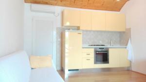 a small kitchen with white cabinets and a stove at Sea View Apartment Maćus in Koločep
