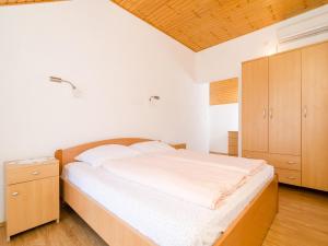 1 dormitorio con 1 cama grande y armario de madera en Holiday Home Macus en Koločep