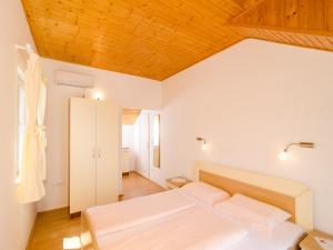 a bedroom with two beds and a wooden ceiling at Holiday Home Macus in Koločep