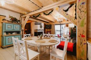 a kitchen and dining room with a table and chairs at PUSZCZYKOWO siedlisko&spa in Białowieża