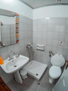 a white bathroom with a sink and a toilet at Ena-Lia Studios in Skala Marion