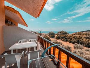 een balkon met stoelen en een tafel en de oceaan bij Ena-Lia Studios in Skala Marion