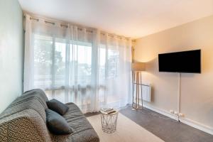 a living room with a couch and a flat screen tv at Kersalé in Bénodet