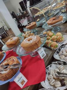a buffet filled with different types of cakes and pastries at Nova Vicenza Hotel in Farroupilha