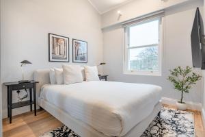 biała sypialnia z dużym łóżkiem i oknem w obiekcie Be London - Maida Vale Residences w Londynie