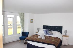 a bedroom with a bed and a blue chair at Cippinstone in Newport Pembrokeshire