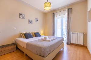 a bedroom with a large bed and a large window at Casa no Sitio in Nazaré