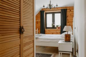 1 Schlafzimmer mit 2 Betten und einem Fenster in der Unterkunft PUSZCZYKOWO siedlisko&spa in Białowieża