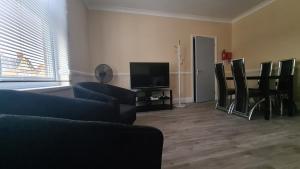 a living room with a couch and chairs and a television at Entire 2 Bedroom Home/Flat In London, Central Line in London